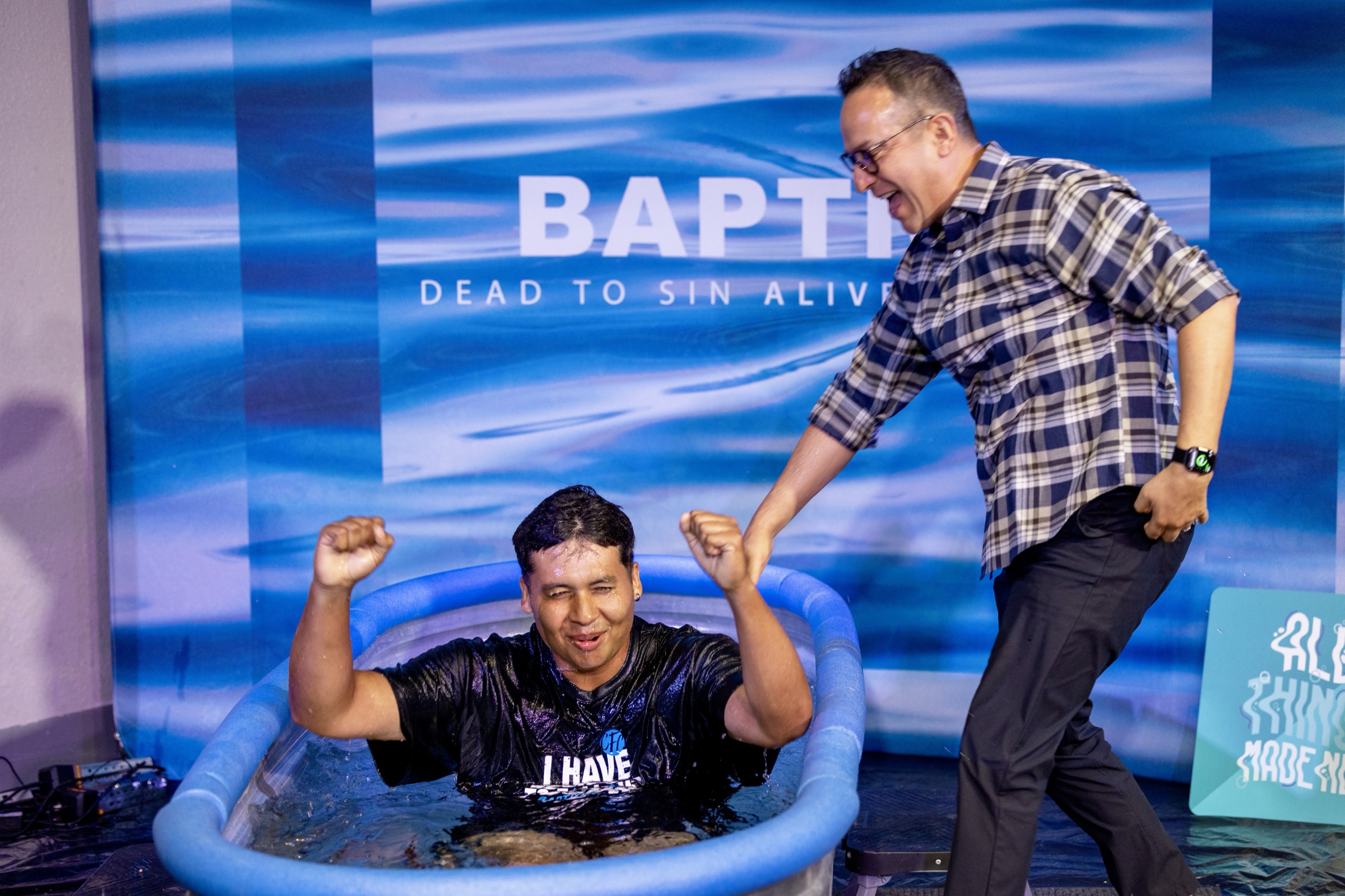 A man celebrating in the tank after his baptism
