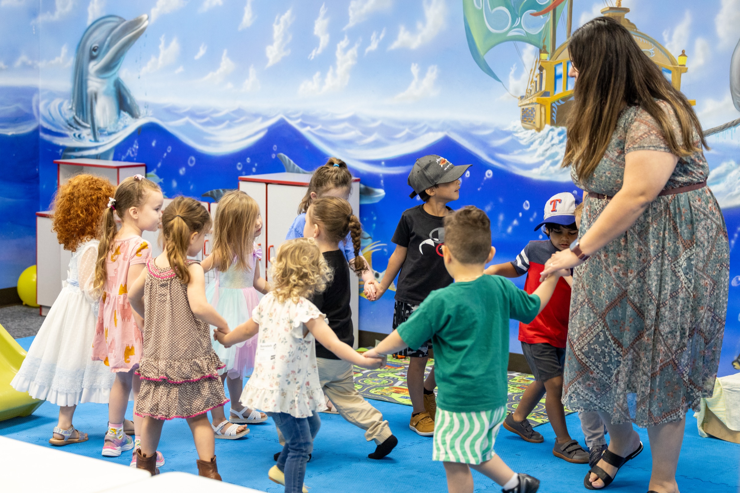 Kids and a leader dancing in a circle in Children's Ministry