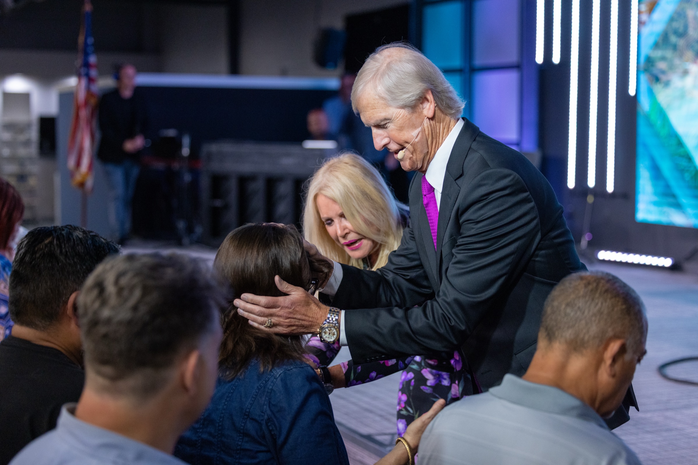 Dr Theo and Dr Bev praying for people at the front after a service