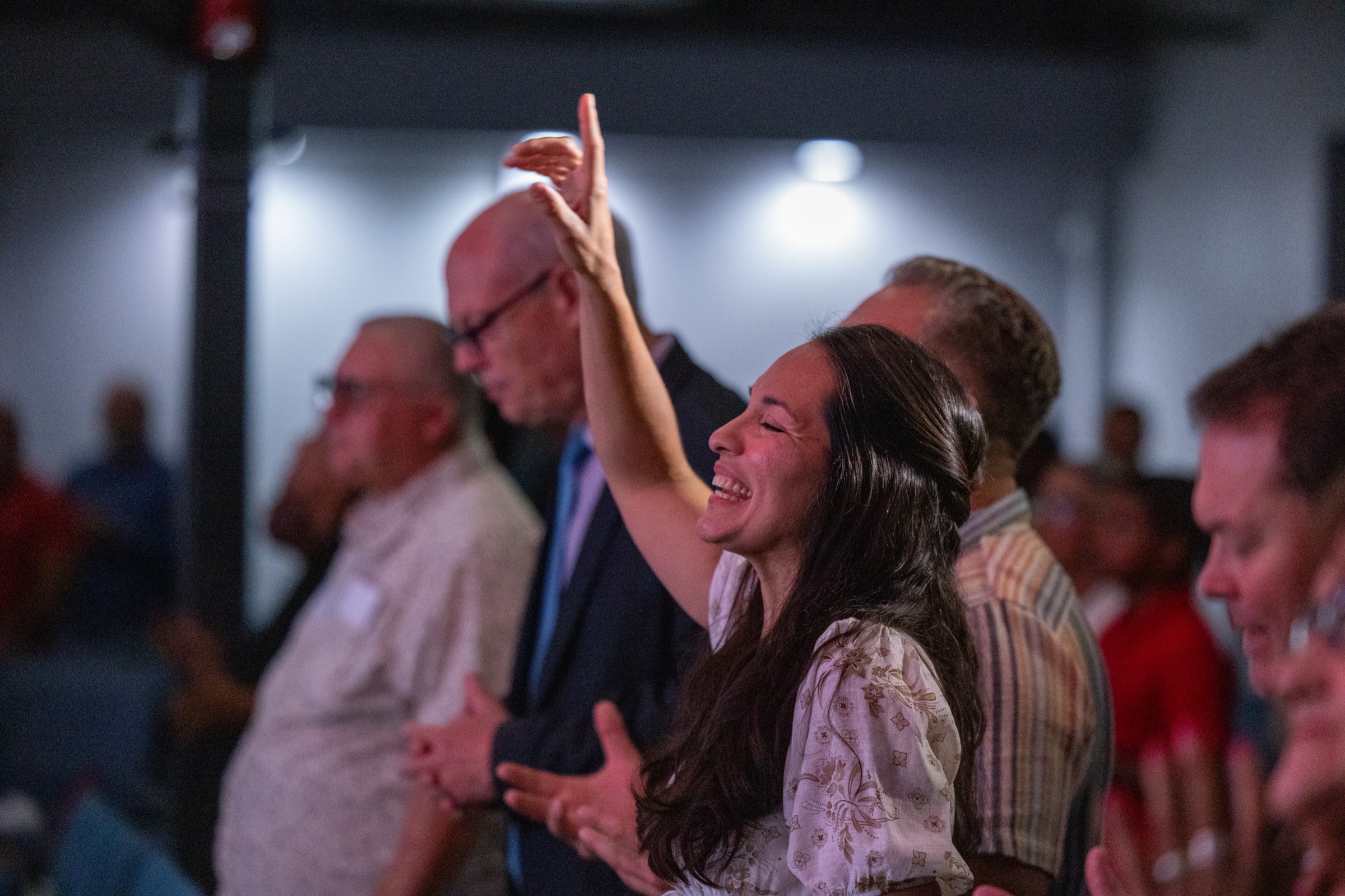 A woman worshipping with her hand raised during a service